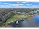 Aerial view of a waterfront property with a boat dock, lush green lawn, and mature trees at 1102 N Palmetto St, Leesburg, FL 34748