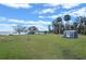 Expansive backyard featuring a storage shed, lush lawn and mature trees on a waterfront property at 1102 N Palmetto St, Leesburg, FL 34748