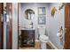 Compact half-bathroom featuring a wood-look vanity, bowl sink, and coastal-themed decor at 1102 N Palmetto St, Leesburg, FL 34748