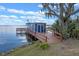 Waterfront dock featuring a seating area and shed, perfect for lakeside relaxation and boat storage at 1102 N Palmetto St, Leesburg, FL 34748