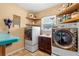 Bright laundry room with modern appliances, sink, and ample storage space with custom shelving at 1102 N Palmetto St, Leesburg, FL 34748