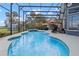 A screened-in pool, complemented by a relaxing lounge area and green surroundings at 1102 N Palmetto St, Leesburg, FL 34748