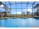 A serene view from the pool, showcasing a well-manicured lawn and the tranquil lake at 1102 N Palmetto St, Leesburg, FL 34748