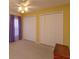 Bedroom with two closets, ceiling fan, and beige carpeting at 1123 Bluegrass Dr, Groveland, FL 34736