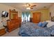 Bright bedroom features an iron bed frame, ceiling fan, and a wooden dresser at 1123 Bluegrass Dr, Groveland, FL 34736