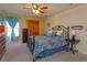 Bright bedroom features an iron bed frame, ceiling fan, and a wooden armoire at 1123 Bluegrass Dr, Groveland, FL 34736