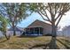 Rear exterior view of the home and screened lanai overlooking the backyard at 1123 Bluegrass Dr, Groveland, FL 34736