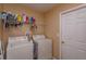 A functional laundry room with a washer and dryer, shelving, and ample space for laundry essentials at 1123 Bluegrass Dr, Groveland, FL 34736