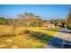 Scenic view of the property featuring open land, a red barn and treelined borders at 11325 Michael John Rd, Howey In The Hills, FL 34737