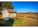 Exterior of a storage shed featuring vertical siding with double doors, set amidst a backdrop of open, grassy land at 11325 Michael John Rd, Howey In The Hills, FL 34737