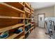 Functional storage room with wood shelving, laundry area, and tile flooring at 11325 Michael John Rd, Howey In The Hills, FL 34737