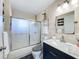 Bright bathroom featuring decorative shower door, vanity with storage, and neutral tile at 119 Cory Ct, Auburndale, FL 33823