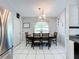 Open dining room with seating for six, white tile floors, and stainless refrigerator at 119 Cory Ct, Auburndale, FL 33823