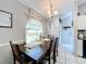 Dining area with a wooden table set for six, chandelier, and bright window at 119 Cory Ct, Auburndale, FL 33823