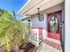 Charming front porch with decorative wreath on a red door and a well-kept garden at 119 Cory Ct, Auburndale, FL 33823