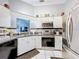 Well-lit kitchen featuring white cabinets, stainless steel appliances, and a neutral countertop at 119 Cory Ct, Auburndale, FL 33823