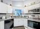 Functional kitchen featuring stainless steel appliances, white cabinets, and modern fixtures at 119 Cory Ct, Auburndale, FL 33823