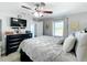 Cozy main bedroom with a ceiling fan, black dresser, and large window at 119 Cory Ct, Auburndale, FL 33823