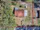 An aerial view of a modest single-story home, showcasing its roof and surrounding treed yard at 11915 Cr 680, Webster, FL 33597