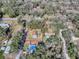 Aerial view of a property with a tree-filled lot; the home has a fenced yard and outbuildings at 11915 Cr 680, Webster, FL 33597