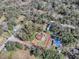 Aerial view showing a home on a partially wooded lot with a fenced yard and neighboring properties at 11915 Cr 680, Webster, FL 33597