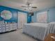 Bright bedroom with blue walls, ceiling fan, dresser, and white patterned bedspread at 11915 Cr 680, Webster, FL 33597