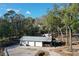 Detached garage with multiple bays and an attached carport surrounded by trees at 1205 Darcy Rd, Lady Lake, FL 32159