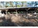 A horse barn featuring wooden construction and a metal roof, designed for animal shelter and storage, located in a lush, green area at 1205 Darcy Rd, Lady Lake, FL 32159