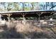 A horse barn featuring wooden construction and a metal roof, designed for animal shelter and storage, located in a lush, green area at 1205 Darcy Rd, Lady Lake, FL 32159