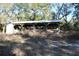 A horse barn featuring wooden construction and a metal roof, designed for animal shelter and storage, located in a lush, green area at 1205 Darcy Rd, Lady Lake, FL 32159