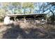 A horse barn featuring wooden construction and a metal roof, designed for animal shelter and storage, located in a lush, green area at 1205 Darcy Rd, Lady Lake, FL 32159