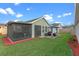 A covered lanai offers comfortable seating and dining areas in this well-maintained backyard at 123 Bayou Bend Rd, Groveland, FL 34736