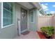 Inviting front entry with a decorative glass door, 'welcome' sign, and lush potted plants at 123 Bayou Bend Rd, Groveland, FL 34736