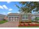 Charming home featuring stone accents, complemented by brick pavers and colorful landscaping at 123 Bayou Bend Rd, Groveland, FL 34736