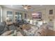 Open-concept living room with wood floors, plantation shutters, neutral tones, and comfortable seating at 123 Bayou Bend Rd, Groveland, FL 34736