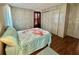 Bedroom with wood floors, flamingo themed comforter, closet, and furnishings at 133 Hibiscus Way, Leesburg, FL 34748