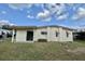 Home exterior featuring a grassy yard and partial view of the back of the building at 133 Hibiscus Way, Leesburg, FL 34748