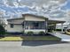 Charming home featuring a covered carport, a screened-in porch, and manicured landscaping at 133 Hibiscus Way, Leesburg, FL 34748