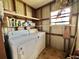 Functional laundry room with washer, dryer, and shelving for storage at 133 Hibiscus Way, Leesburg, FL 34748