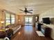 Inviting living room with hardwood floors, ceiling fan, sliding doors and a faux fireplace at 133 Hibiscus Way, Leesburg, FL 34748