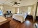 Bright main bedroom with wood floors, ceiling fan, mirrored closet, and furnishings at 133 Hibiscus Way, Leesburg, FL 34748