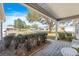 Inviting covered patio with brick pavers and peaceful views of the landscaped front yard and surrounding neighborhood at 1402 Sanchez Ct, The Villages, FL 32159