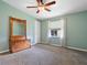 This bedroom is painted green with carpet flooring, ceiling fan, and wooden furniture at 1417 E Schwartz Blvd, The Villages, FL 32159