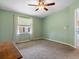 This bedroom is painted green with carpet flooring and a ceiling fan at 1417 E Schwartz Blvd, The Villages, FL 32159