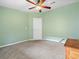 This bedroom is painted green with carpet flooring and a ceiling fan at 1417 E Schwartz Blvd, The Villages, FL 32159