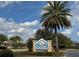 Community sign for Dunedin Pool with nice landscaping and clear blue skies at 1607 Quaker Ct, The Villages, FL 32163