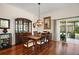 Dining room with hardwood floors, dining table, chandelier, and sliding glass doors to the lanai at 1607 Quaker Ct, The Villages, FL 32163