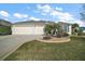 Charming single-story home with a well-manicured lawn, a two-car garage, and attractive landscaping at 1607 Quaker Ct, The Villages, FL 32163