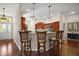 Kitchen bar area with wood floors and cabinets and modern appliances at 1607 Quaker Ct, The Villages, FL 32163