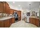 Kitchen featuring stainless steel appliances, backsplash, tile flooring and wood cabinets at 1607 Quaker Ct, The Villages, FL 32163